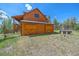 Log home with large double doors and hot tub at 6929 Weasel Way, Evergreen, CO 80439