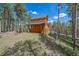 Rustic log cabin nestled in a wooded area at 6929 Weasel Way, Evergreen, CO 80439