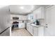 Updated kitchen featuring white shaker cabinets, granite counters, and stainless steel appliances at 1852 S Forest St, Denver, CO 80222