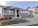 Two-story home with gray siding, three car garage and landscaping at 12689 Sunset Dr, Longmont, CO 80504