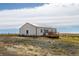 White barn-style home with a deck and rural setting at 35100 E 120Th Ave, Hudson, CO 80642