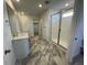 Main bathroom with double vanity, marble flooring and shower at 12909 Range St, Firestone, CO 80504