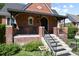 Brick front porch with awning and black metal railing at 1529 Holly, Denver, CO 80220