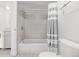 Updated bathroom with gray tile, shower/tub combo, and striped shower curtain at 1265 Race St # 208, Denver, CO 80206