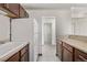 Galley kitchen with white appliances and wood cabinets at 1265 Race St # 208, Denver, CO 80206