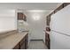 Bright kitchen with white appliances and dark wood cabinets at 1265 Race St # 208, Denver, CO 80206