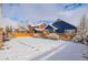 Snowy backyard with a wooden fence and a blue house at 6242 N Genoa St, Aurora, CO 80019