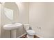 Clean bathroom with pedestal sink, toilet and wood-look floor at 6242 N Genoa St, Aurora, CO 80019