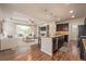 Open concept kitchen with island, dark cabinets, and stainless steel appliances at 6242 N Genoa St, Aurora, CO 80019