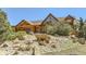 Log home exterior with large windows, landscaping, and rock accents at 12346 Shiloh Point Dr, Littleton, CO 80127