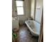 Bathroom with old clawfoot tub and patterned tile floor at 1053 N Colorado Blvd, Denver, CO 80206