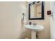 Clean bathroom with pedestal sink and black framed mirror at 738 S Main St, Byers, CO 80103