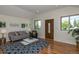Living room with hardwood floors, a cozy seating area, and large windows at 4542 Sheridan Blvd, Denver, CO 80212