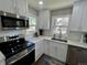 Modern kitchen with white cabinets and stainless steel appliances at 4185 S Logan St, Englewood, CO 80113