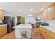 Open kitchen with large island, stainless steel appliances, and hardwood floors at 580 S Parfet St, Lakewood, CO 80226