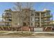 Three-story building exterior with balconies and a tree in front at 1705 Gaylord St # 107, Denver, CO 80206