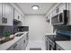 Modern galley kitchen with gray cabinets, quartz countertops, and stainless steel appliances at 14218 E 1St Dr # A05, Aurora, CO 80011