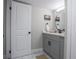 Updated bathroom with gray vanity and a large round mirror at 14218 E 1St Dr # A05, Aurora, CO 80011
