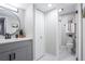 Modern bathroom with gray vanity, a large round mirror, and marble flooring at 14218 E 1St Dr # A05, Aurora, CO 80011