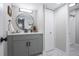 Modern bathroom with gray vanity, a large round mirror, and marble flooring at 14218 E 1St Dr # A05, Aurora, CO 80011