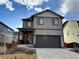 Two-story house with gray siding, a two-car garage, and a well-manicured lawn at 1109 Sunrise Dr, Lochbuie, CO 80603