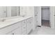 Modern bathroom with double vanity, marble-tiled floors, and walk-in closet at 446 Millwall Cir, Castle Pines, CO 80108