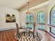 Charming dining room with a round glass table and a view of the wooded backyard at 26600 Mowbray Ct, Evergreen, CO 80439