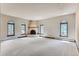 Bright Gathering room with a fireplace and large windows, carpeted floors at 26600 Mowbray Ct, Evergreen, CO 80439