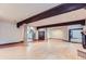 Spacious living room featuring hardwood floors, wood beams, and a view to the hallway at 26600 Mowbray Ct, Evergreen, CO 80439