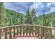 Deck overlooking a lush forest landscape at 26600 Mowbray Ct, Evergreen, CO 80439