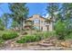 Luxury home with stonework and landscaping on a hillside setting at 26600 Mowbray Ct, Evergreen, CO 80439