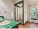 Bathroom with a walk-in shower, green tile, and a window with sheer curtains at 26600 Mowbray Ct, Evergreen, CO 80439