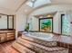 Elegant bathroom with large soaking tub, stained glass window, and terracotta tile at 26600 Mowbray Ct, Evergreen, CO 80439
