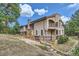 A luxurious home with stone accents and a balcony overlooking the landscape at 26600 Mowbray Ct, Evergreen, CO 80439
