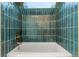 Spa-like bathroom with teal tile and a soaking tub at 17004 E Tennessee Dr # 210, Aurora, CO 80017