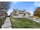 Townhouse exterior showcasing a gray building with a grassy area and walkway at 17004 E Tennessee Dr # 210, Aurora, CO 80017