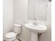 Simple and clean bathroom with pedestal sink and toilet at 2174 Farmlore Dr, Brighton, CO 80601