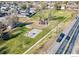 Aerial view of a neighborhood park with playground and basketball court at 1219 Lilac Dr, Lochbuie, CO 80603