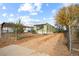 View of the mobile home from the driveway, showing the front and side of the house at 1219 Lilac Dr, Lochbuie, CO 80603