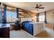 Main bedroom with a rustic accent wall and ceiling fan at 10935 Acadia, Parker, CO 80138