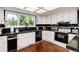 Galley kitchen with granite countertops and white cabinets at 7846 Village Rd, Parker, CO 80134