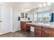 Double vanity bathroom with wood cabinets and large mirror at 325 Crosshaven Pl, Castle Rock, CO 80104