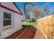 Backyard with grass, mature trees, and a wooden fence at 1565 Xanthia St, Denver, CO 80220