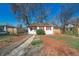 Cute bungalow with red trim, landscaped yard, and wood fence at 1565 Xanthia St, Denver, CO 80220