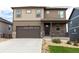 Two-story house with brown and beige exterior, two-car garage, and landscaped yard at 15898 Little Bluestem Rd, Monument, CO 80132