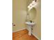 Convenient powder room with pedestal sink and wood-look floors at 6145 S Paris St, Greenwood Village, CO 80111