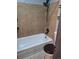 Bathroom with tub shower combo and tan tile at 3550 S Harlan St # 313, Denver, CO 80235