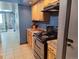 Kitchen boasts wood cabinets, black appliances, and tile flooring at 3550 S Harlan St # 313, Denver, CO 80235