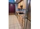 Bright kitchen with wood cabinets, double sink, and tile flooring at 3550 S Harlan St # 313, Denver, CO 80235