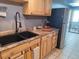 Clean kitchen with a double sink and wood cabinets at 3550 S Harlan St # 313, Denver, CO 80235